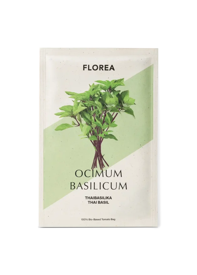 Tajska bazylia – „Bazylia tajska” – Organiczna, w 100% bio-bazowa torba. Na zdjęciu świeże zielone łodygi i liście tajskiej bazylii (Ocimum basilicum), idealne do domowych ogrodów ziołowych. Tekst zawiera „Thaibasilika” i „Thai Basil”. Ekologiczne opakowanie nasion idealne do zrównoważonego ogrodnictwa z internetowego butiku ogrodniczego.